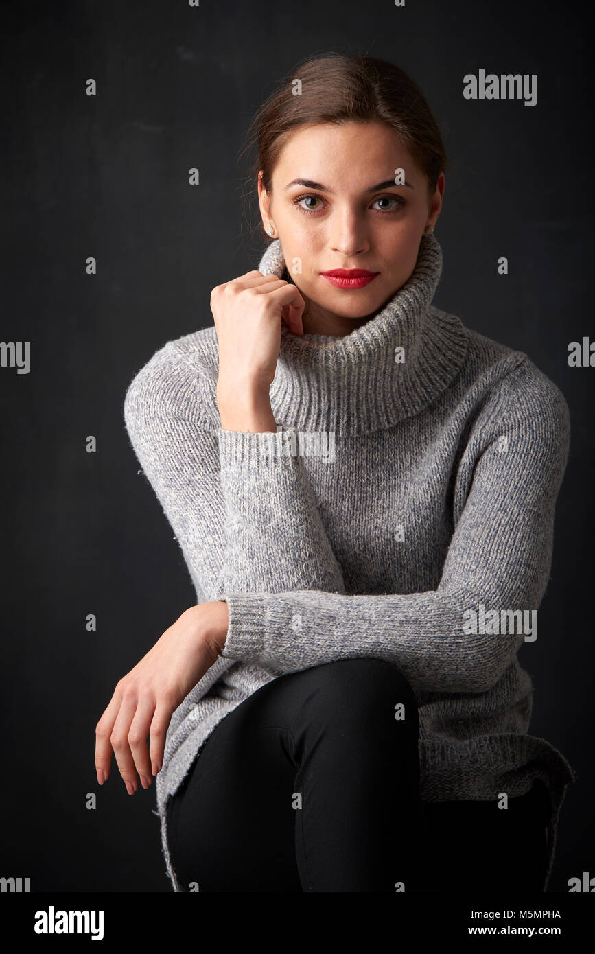 Portrait of beautiful young woman looking at camera and smiling while ...