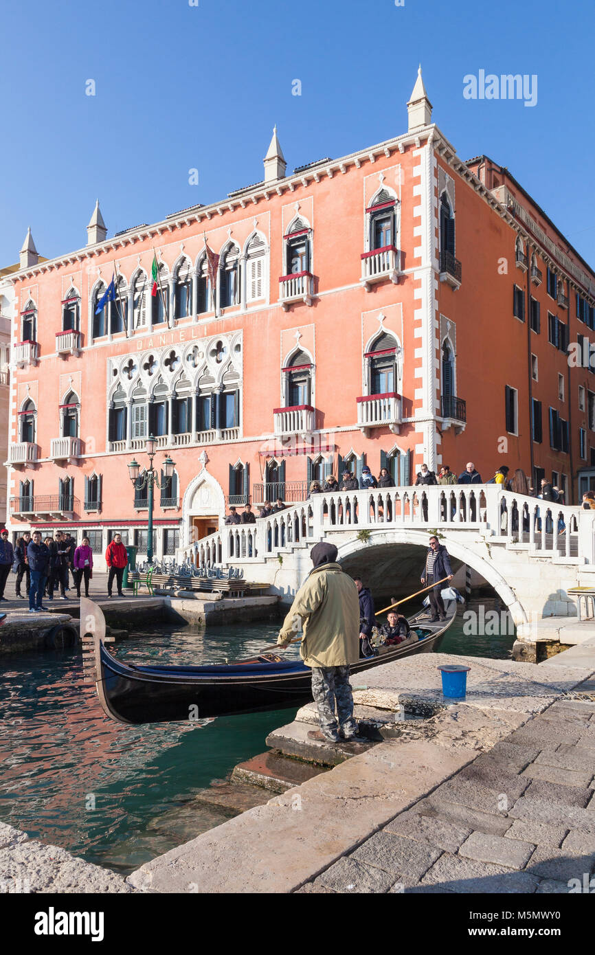 Man standing by with a grapple for a gondola outside the Danieli Hotel, Riva degli Schiavoni, San marco, Venice, Italy to secure the boat as the tour Stock Photo