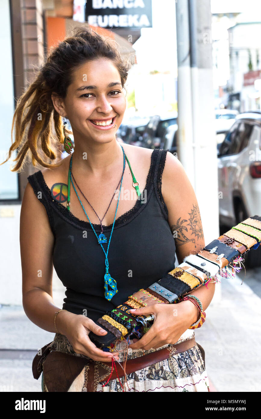 Itajai, Santa Catarina, Brazil - February 22th, 2018: A female brazilian street bracelets vendor, with tattoo and piercing in her face smiling at street. Stock Photo