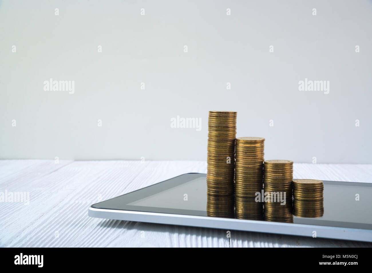 Coin Stack Arithmetic Program Step of coin stack on tablet computer screen on white working table ...