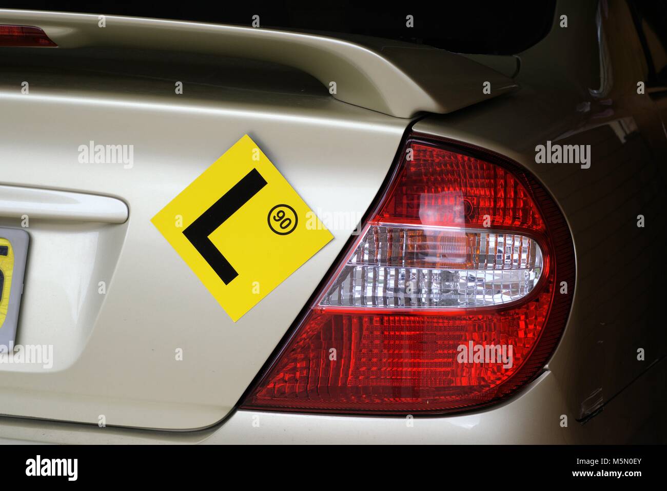 L sign on car with 90 speed limit. Yellow learner's sign. L plate on