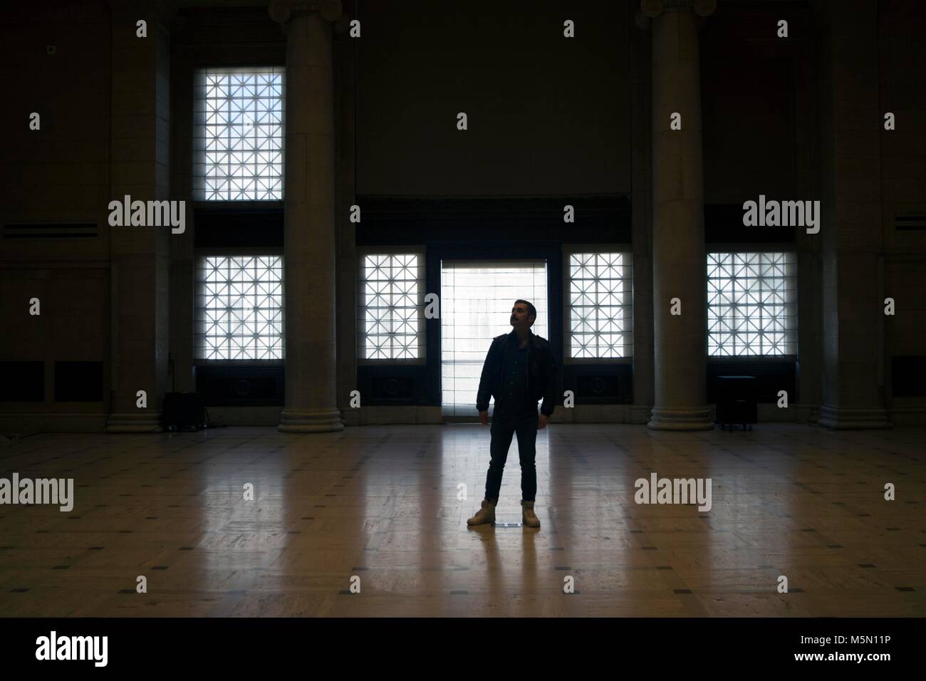 A man stands in the middle of the ballroom at the Asian Art Museum in San Francisco. Stock Photo