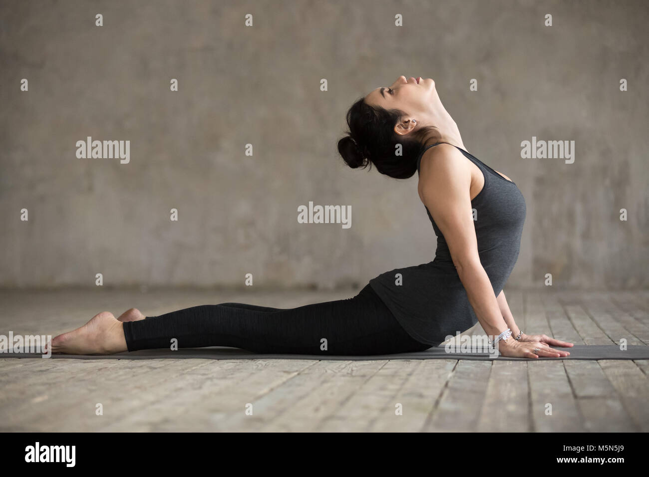 Young woman practicing yoga, doing Cobra exercise, Bhujangasana pose ...