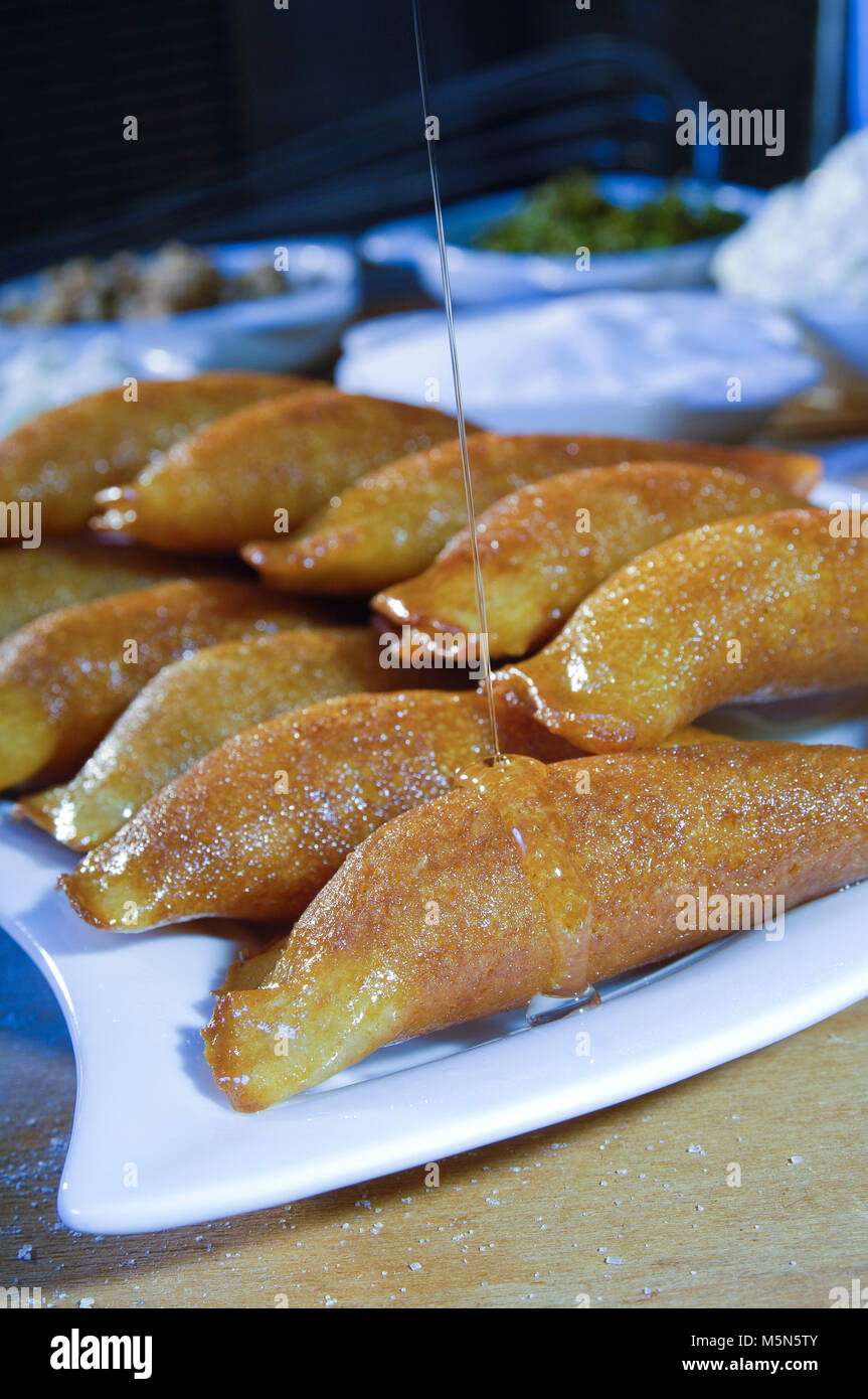 Pouring Syrup on Qatayef, Arabic Sweets with Nuts and Other Ingredients