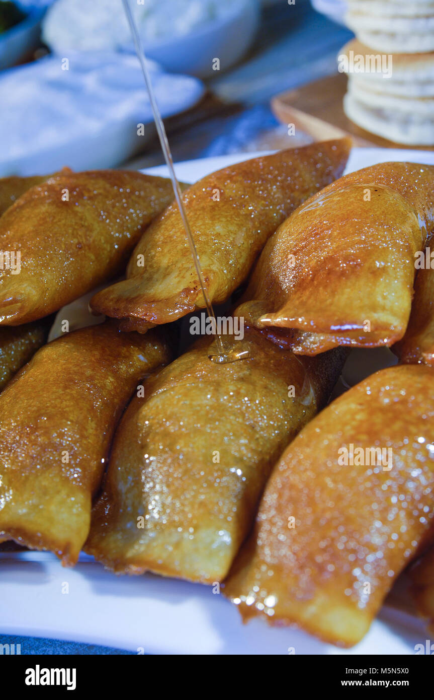 Pouring Syrup on Qatayef, Arabic Sweets with Nuts and Other Ingredients