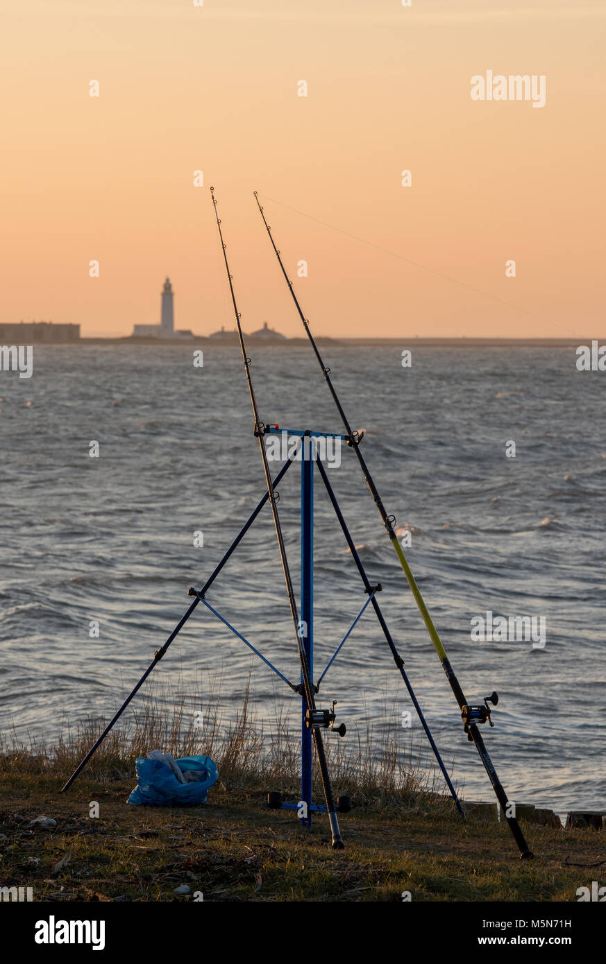 two beach fishing rods on the coast on the isle of wight looking towards  hurst castle at keyhaven near milford on sea, hampshire. angling and fishing  Stock Photo - Alamy