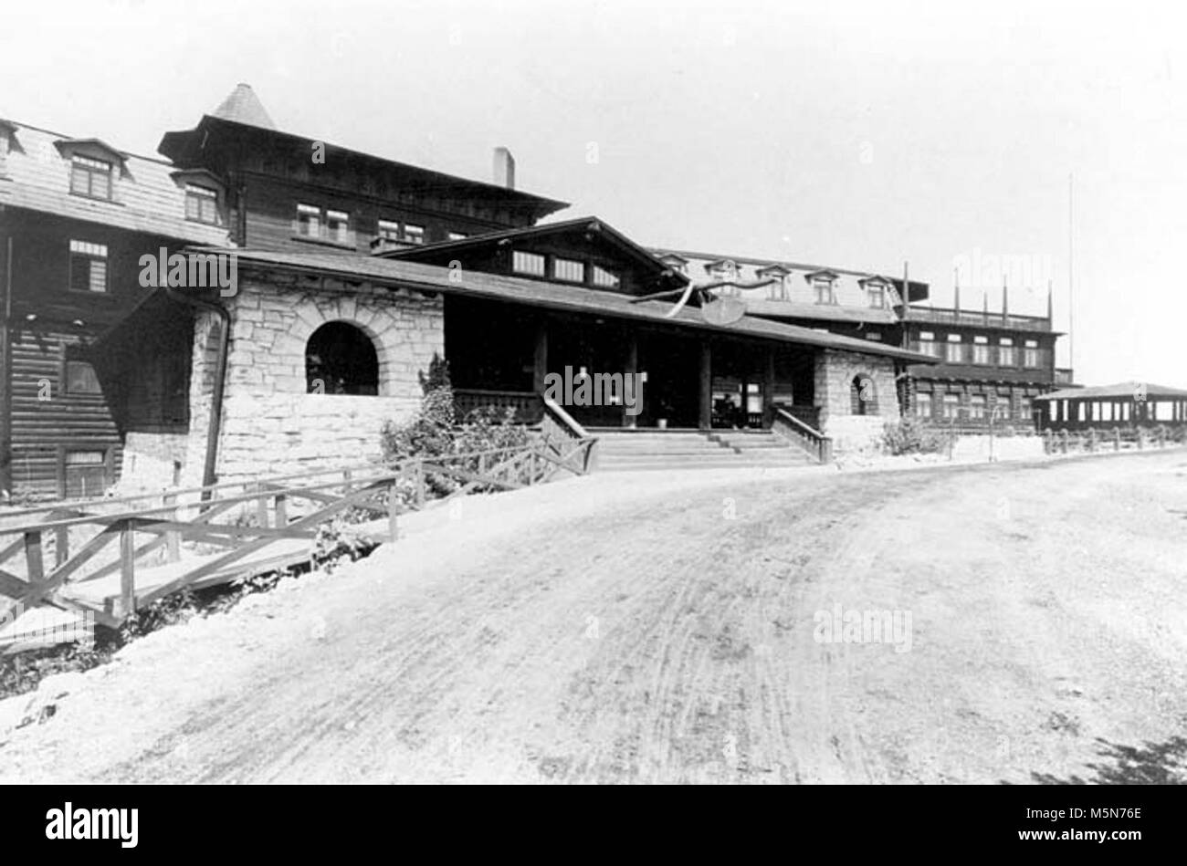 Grand Canyon Historic El Tovar Hotel . EL TOVAR HOTEL FRONT ENTRANCE, LOW ANGLE.  DIRT DRIVEWAY PROMINENT, WITH WHEEL TRACKS. Stock Photo