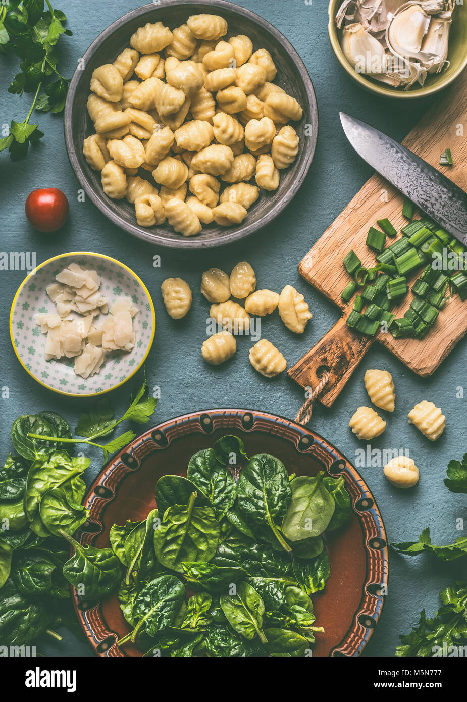 Potato gnocchi with spinach and vegetarian cooking ingredients on rustic table , top view Stock Photo