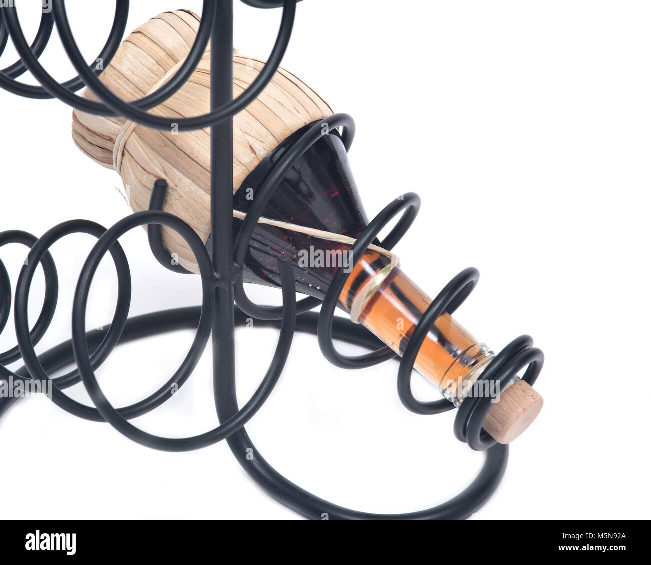 Red pomegranate wine in straw wine bottle and iron wine bottle holder