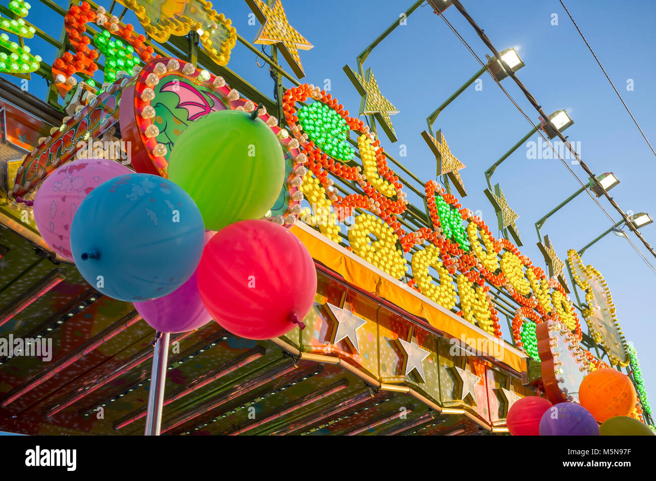 Fairground attraction front plenty of bulbs, leds, balloons and colors. Daylight shot Stock Photo