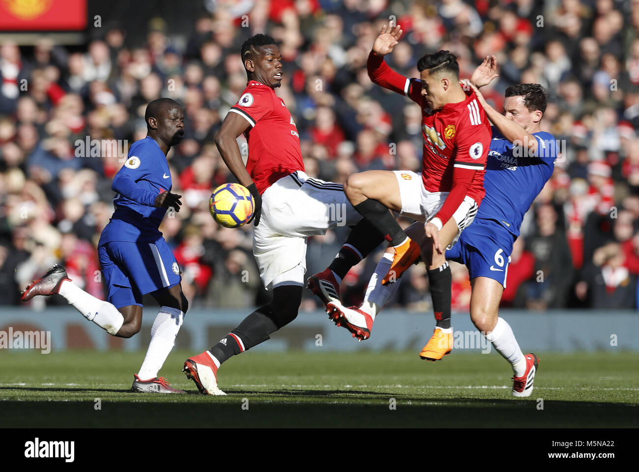 Manchester United's Paul Pogba and Alexis Sanchez challenge for the same ball with Chelsea's Danny Drinkwater (right) during the Premier League match at Old Trafford, Manchester. Stock Photo