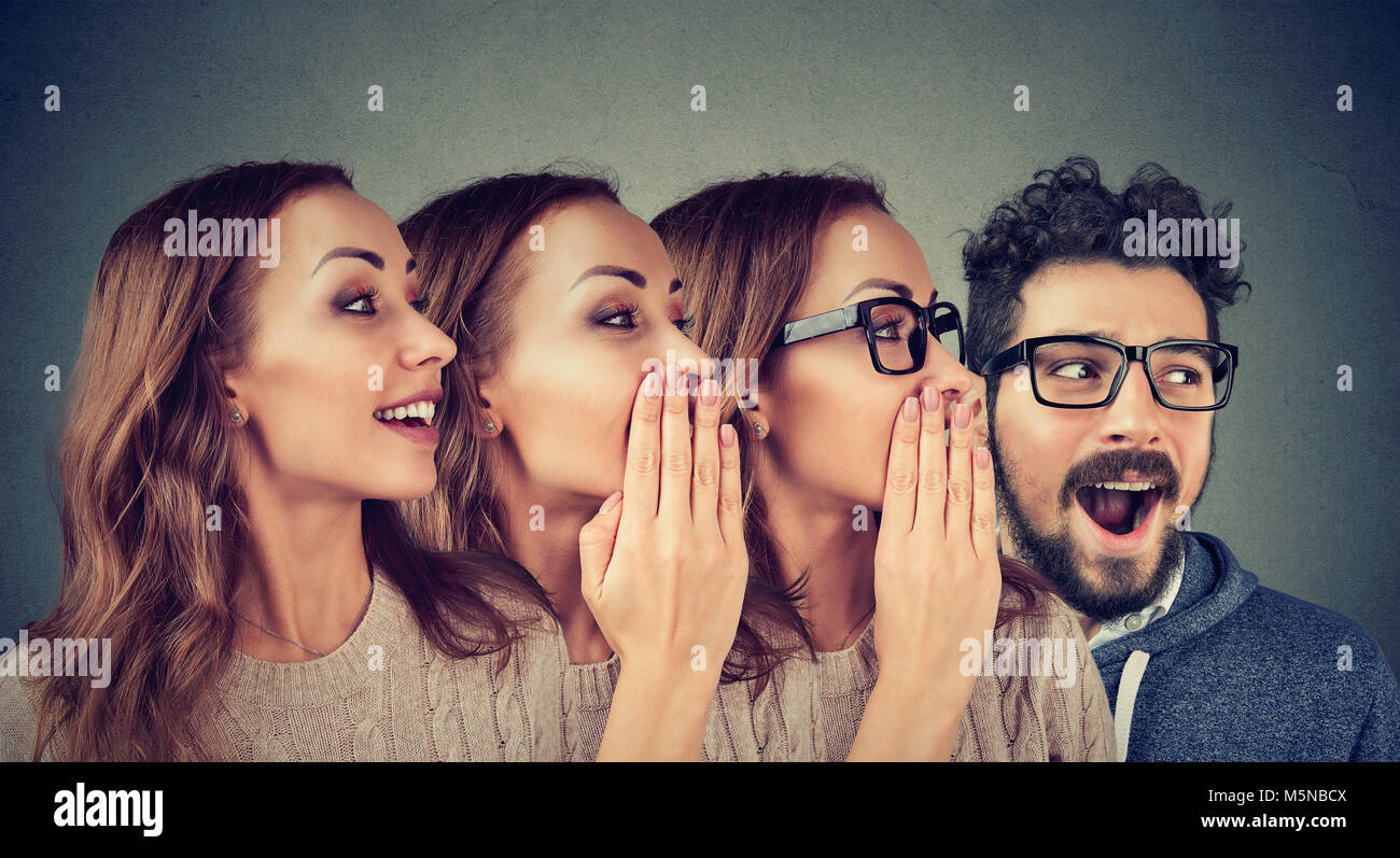 Concept photo of women and man in row sharing with rumour in amazement whispering. Stock Photo