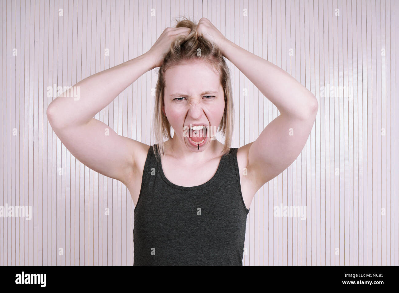 outraged young woman having a temper tantrum shouting and screaming Stock Photo