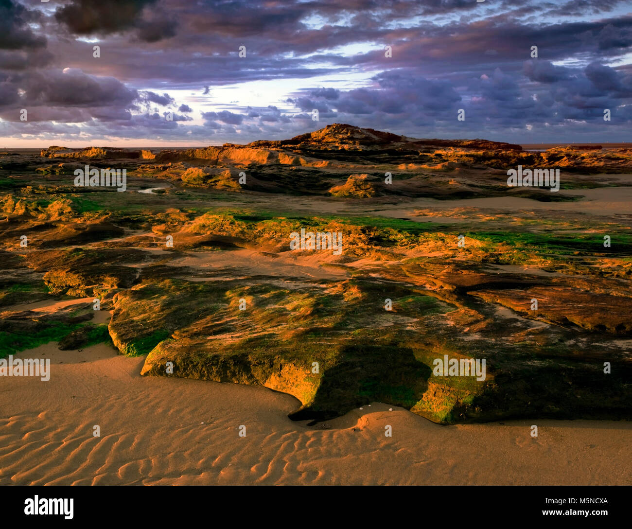 Sunset over the craggy Red Rocks of Hoylake Beach, Wirral, England. Stock Photo