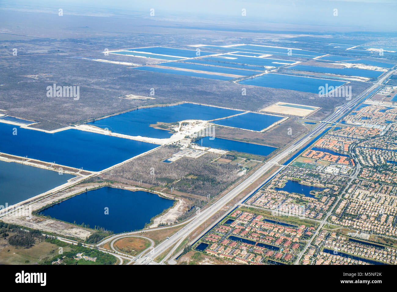 Miami Florida International Airport MIA,American Airlines,flight,Everglades,edge,man made excavation ponds,aerial view,road,land,parcel,encroaching de Stock Photo