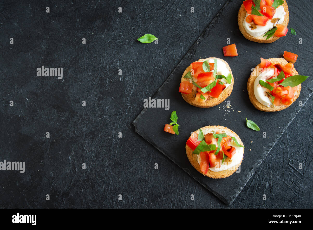 Italian bruschetta with chopped tomatoes, basil, mozzarella cheese and