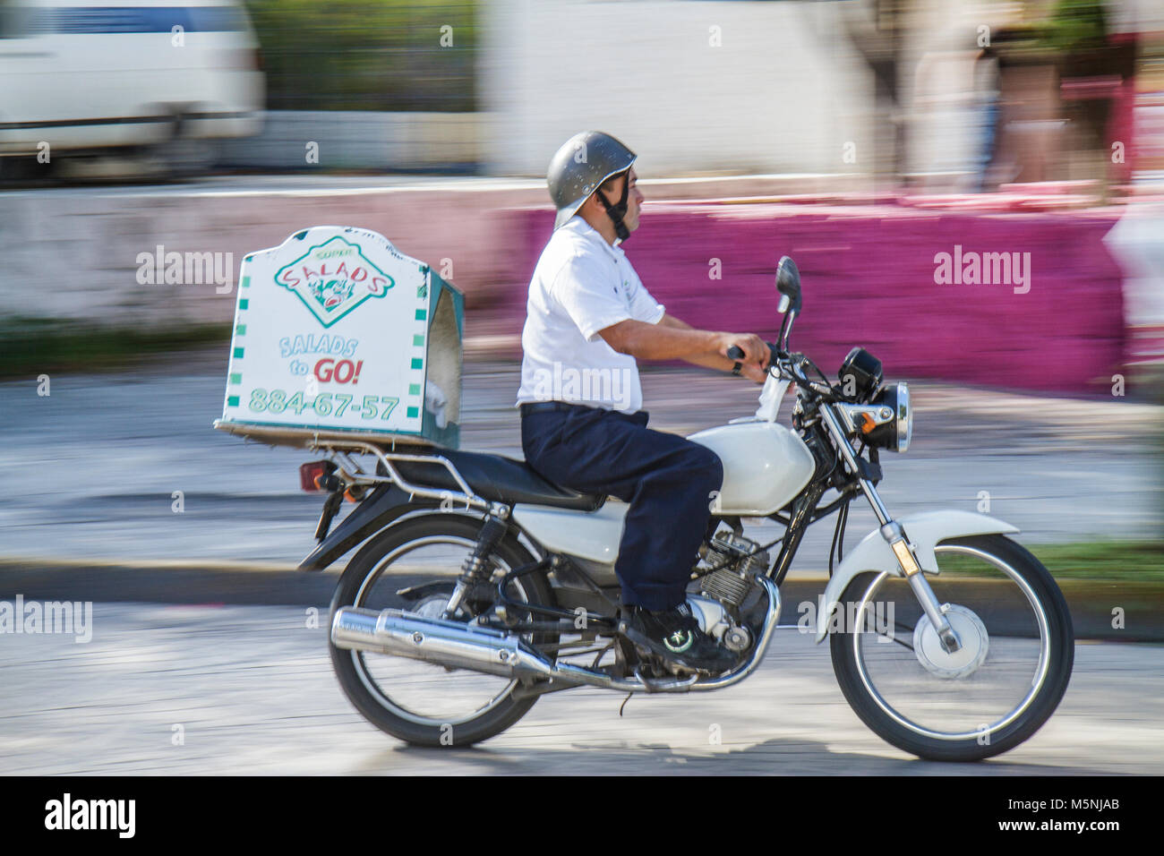 Cancun Mexico,Mexican,Avenida Sunyaxchen,Hispanic man men male adult adults,motorcycle,food delivery,Salads to go,helmet,in motion,Mex101216039 Stock Photo