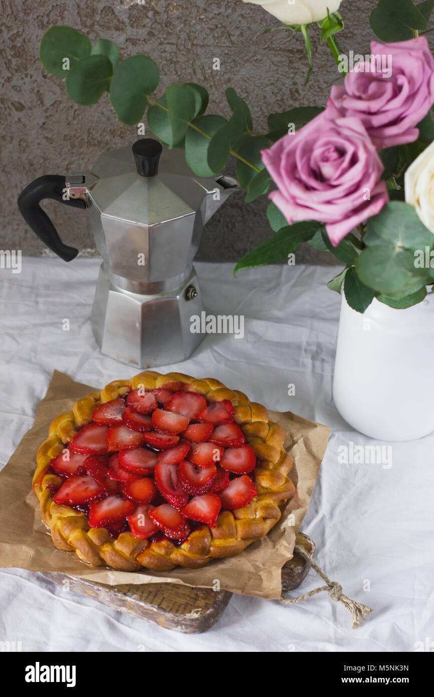 Dining table with flowers, coffee maker and strawberry pie, rustic style Stock Photo
