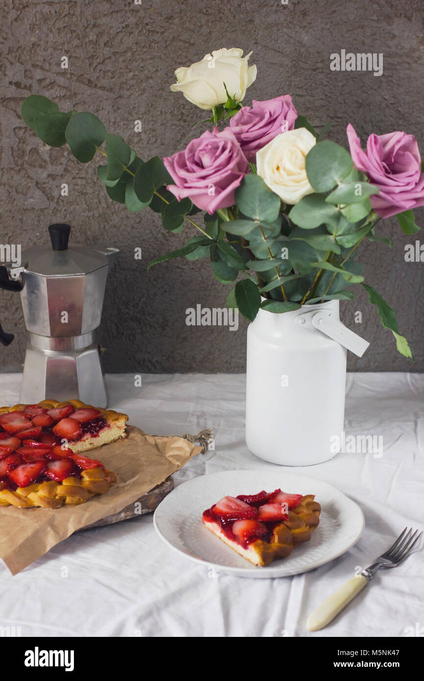 Dining table with flowers, coffee maker and strawberry pie, rustic style Stock Photo