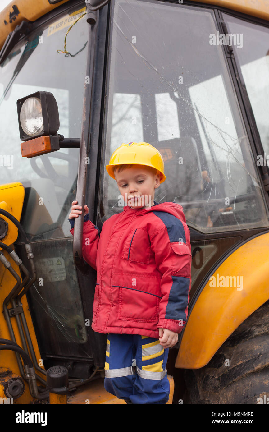 Little boy with a spade helps parents during the construction of the ...