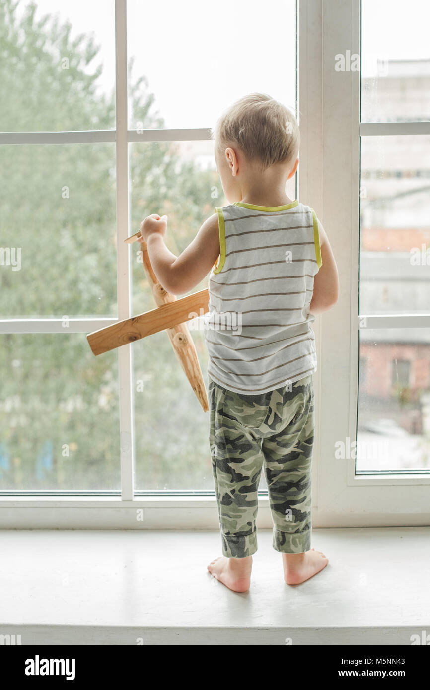 Small child boy looking out Window and Playing Stock Photo - Alamy