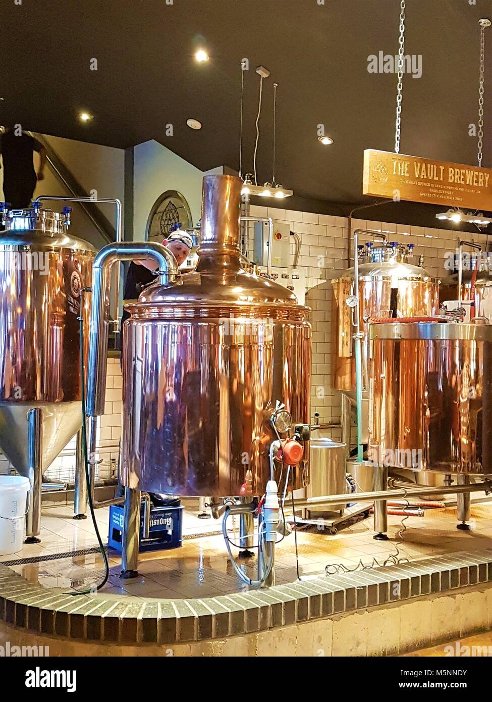 Man brewing beer in copper stills at the Brew House and Kitchen