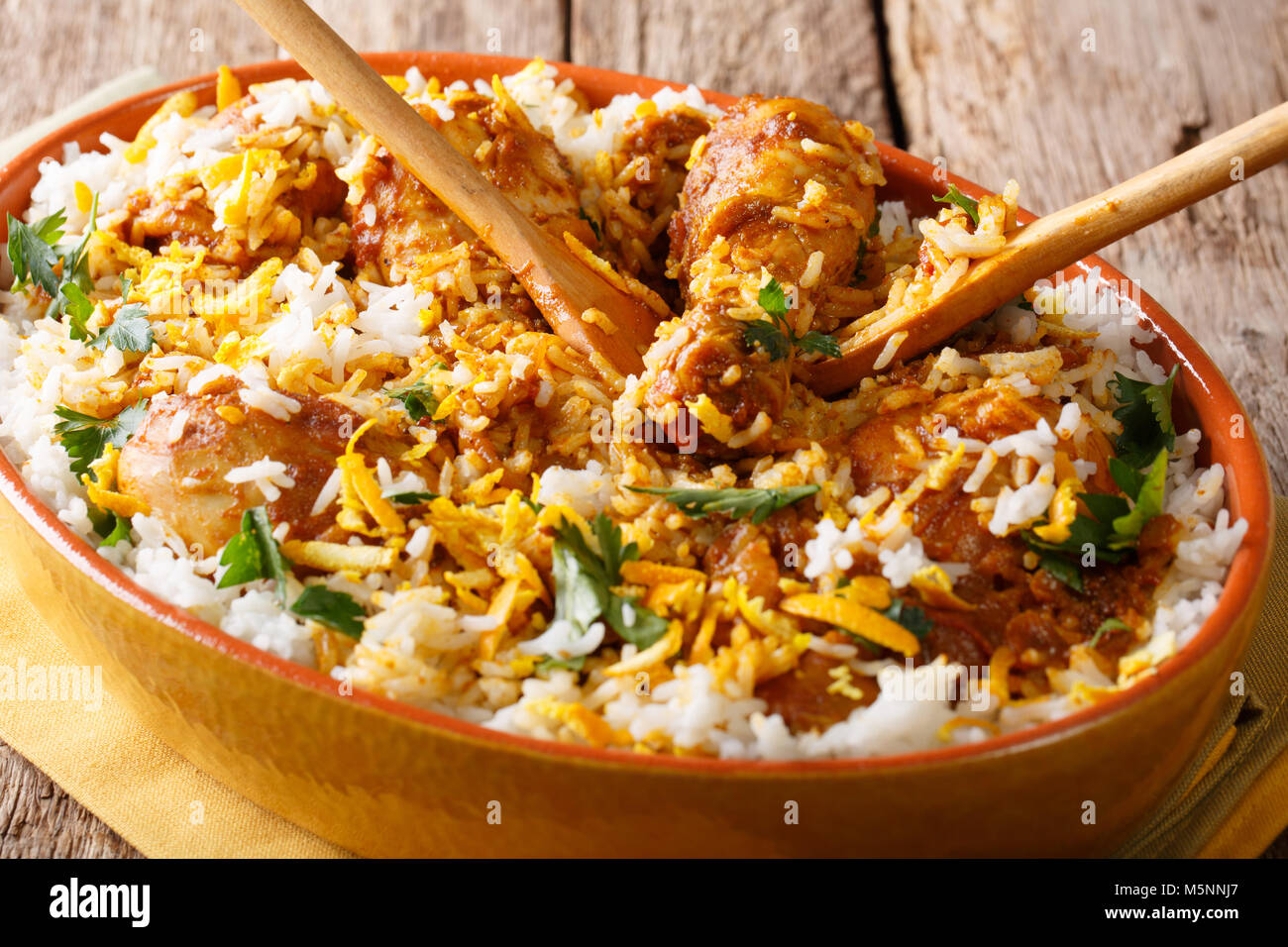 Indian pilaf chicken dum biryani with lemon peel closeup in a platter