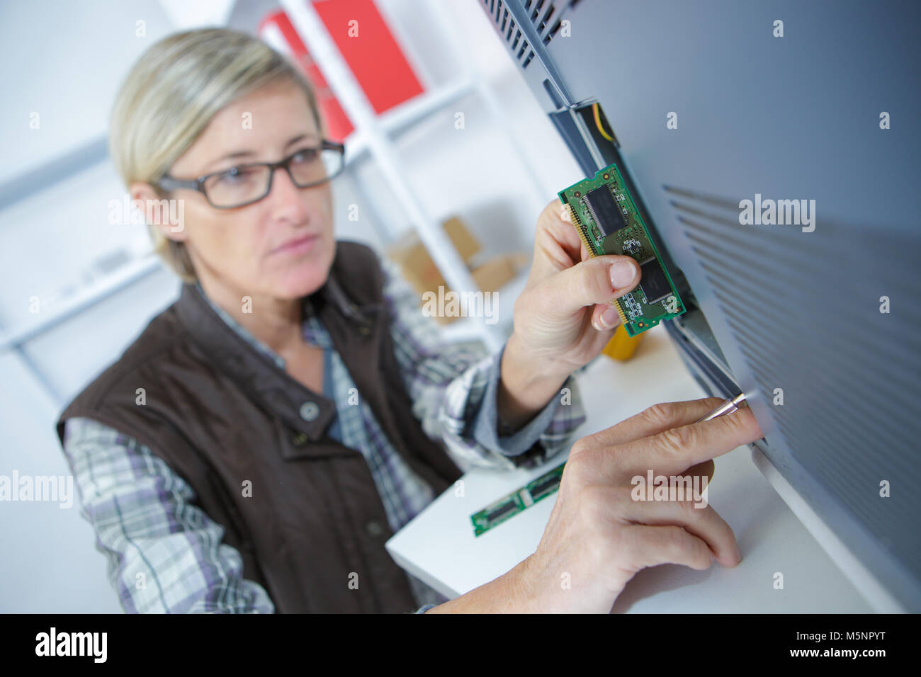 happy woman fixing computer at desk at work Stock Photo Alamy
