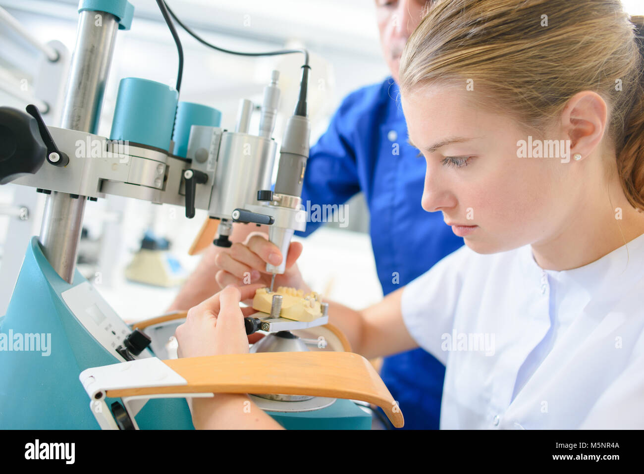 Dental assistant learning on the job Stock Photo