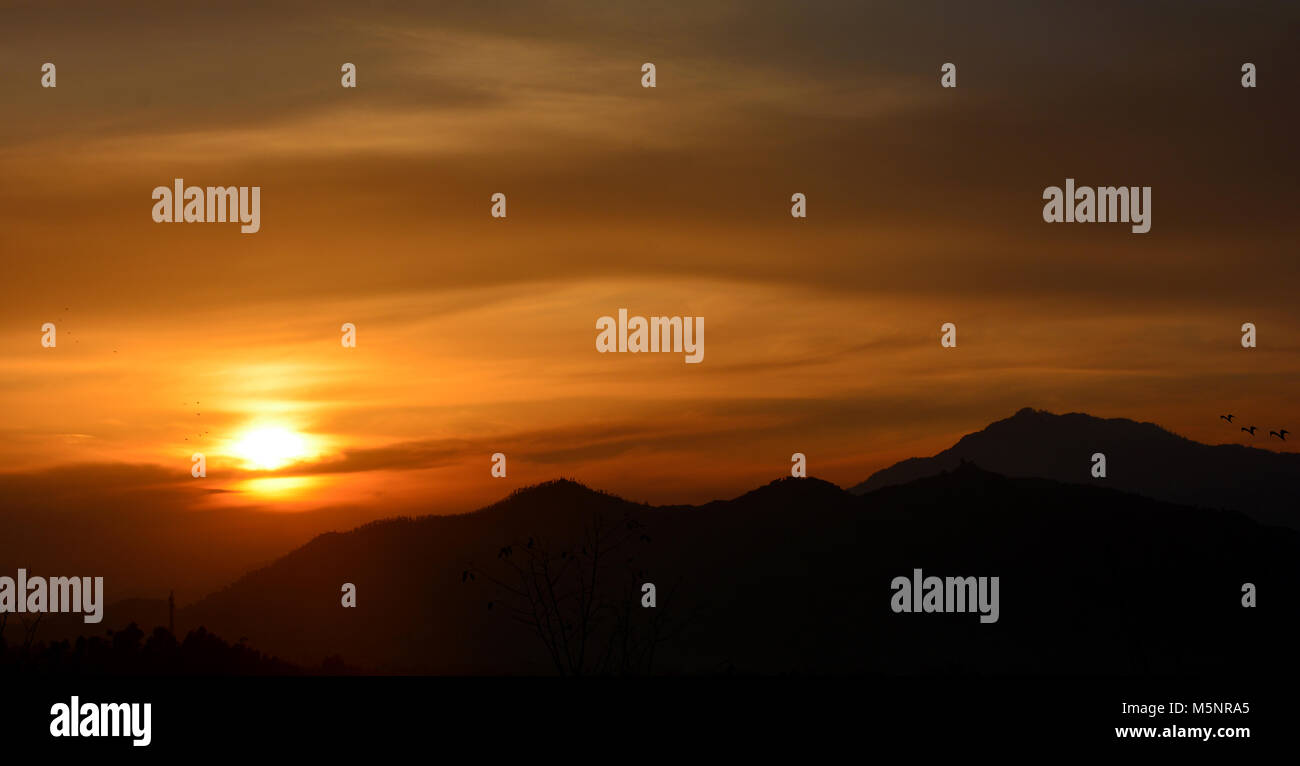Sunset view with dark mountains in the background Stock Photo - Alamy