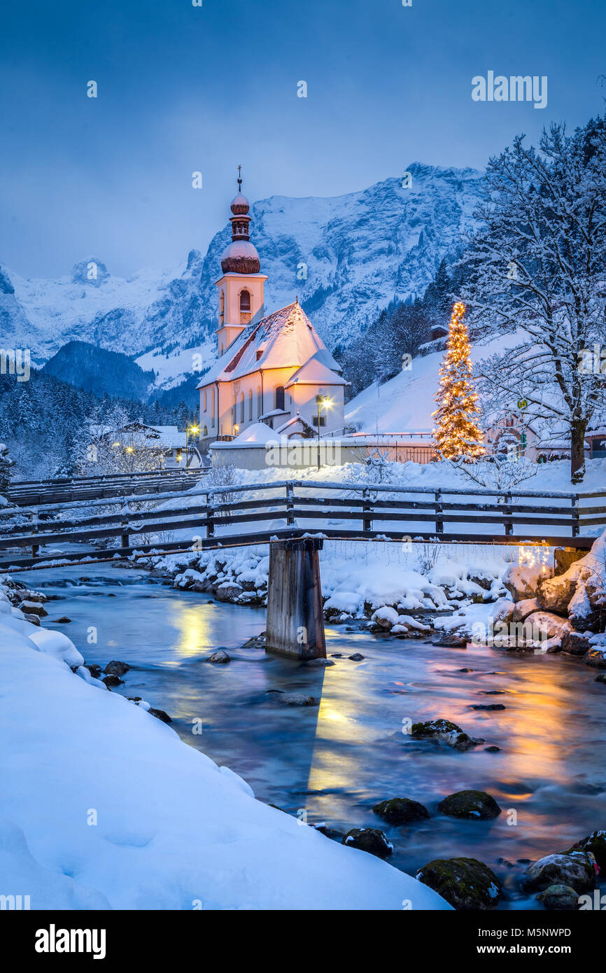 Twilight view of Sankt Sebastian pilgrimage church with Christmas tree illuminated during blue hour at dusk in winter, Ramsau, Bavaria, Germany Stock Photo