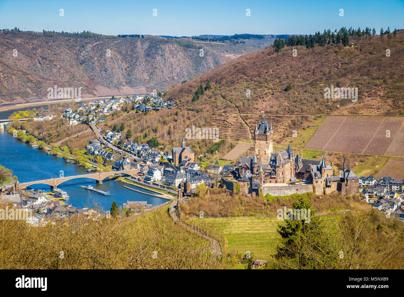 Beautiful aerial view of the historic town of Cochem with famous Reichsburg castle on top of a hill and scenic Moselle river on a sunny day with blue  Stock Photo