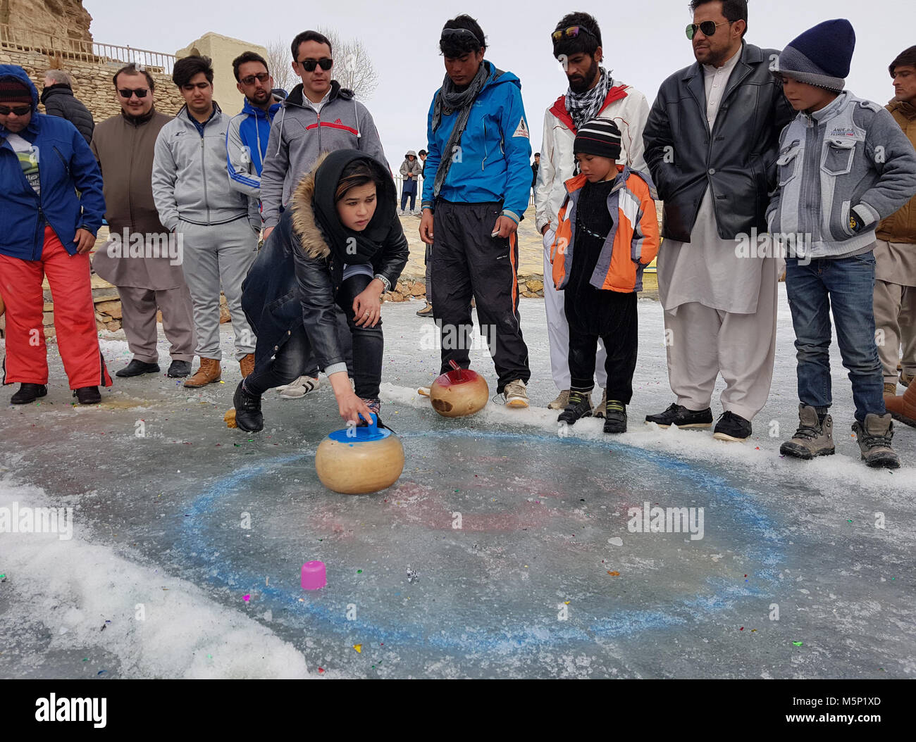 (180225) -- BAMYAN, Feb. 25 (Xinhua) -- A woman plays curling during a winter game festival in Bamyan province, Afghanistan, Feb. 23. 2018. Stock Photo