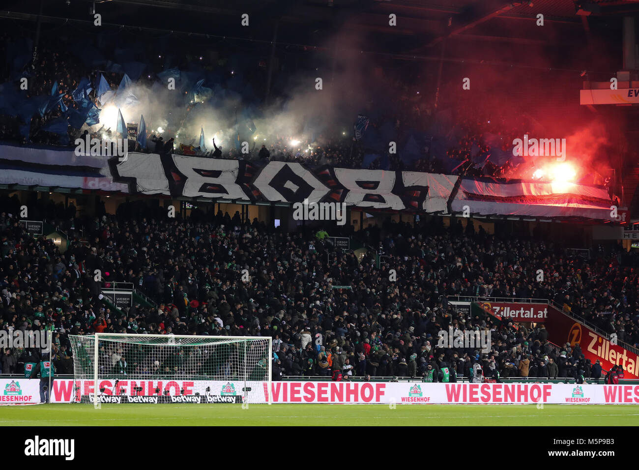 24 Febuary 2018, Germany, Bremen, German Bundesliga soccer match between Werder Bremen and Hamburger SV, Weserstadion: Hamburg's fans light flares. Photo: Christian Charisius/dpa - Nutzung nur nach vertraglicher Vereinbarung Stock Photo