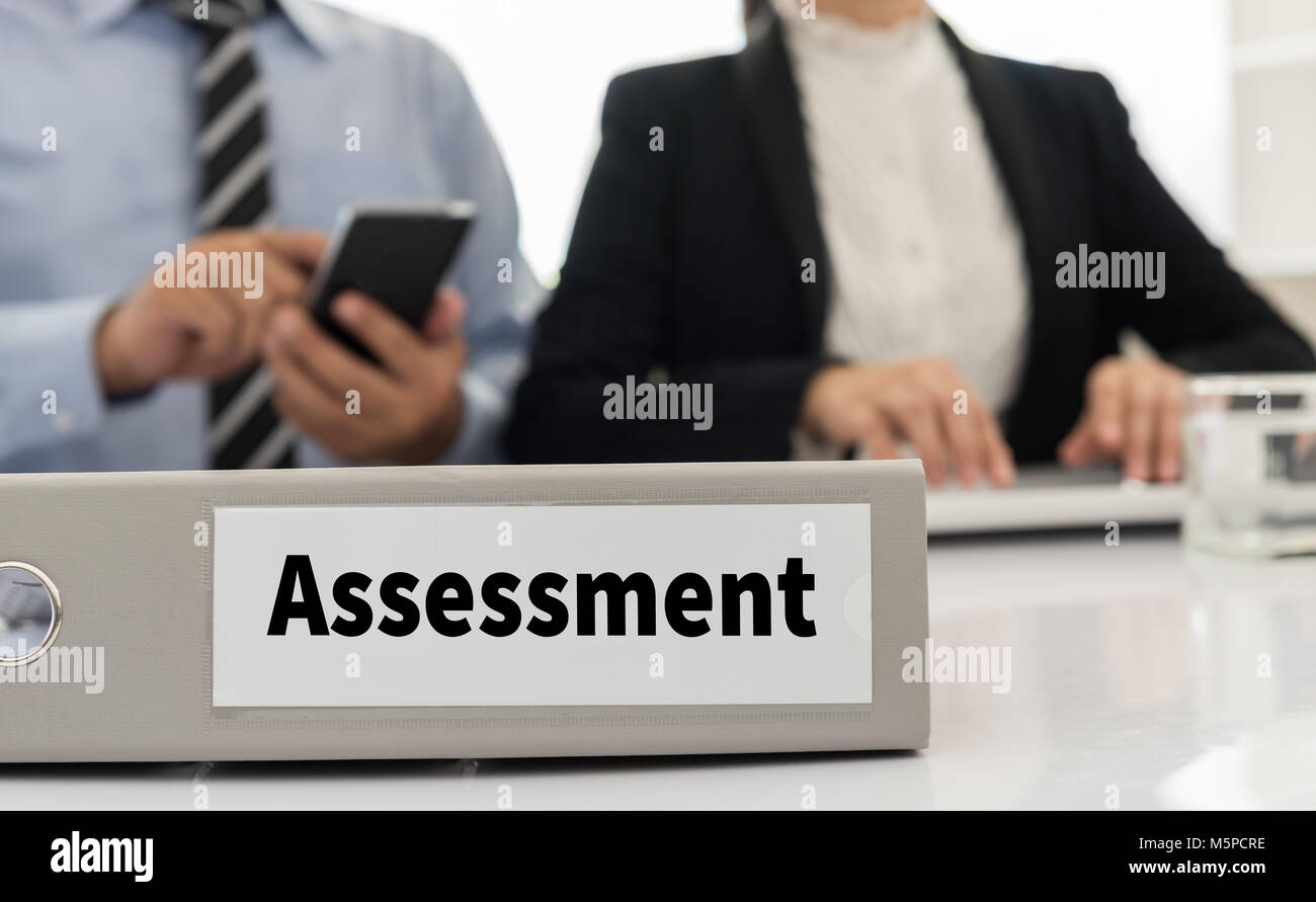 assessment file on desk  with executives and auditors in office. Stock Photo