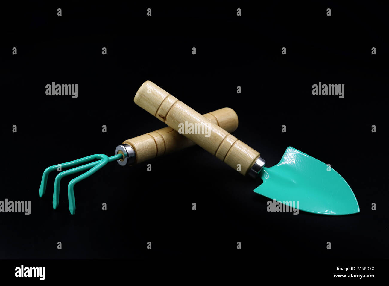 Gardening tools, rake and scoop isolated on black background Stock