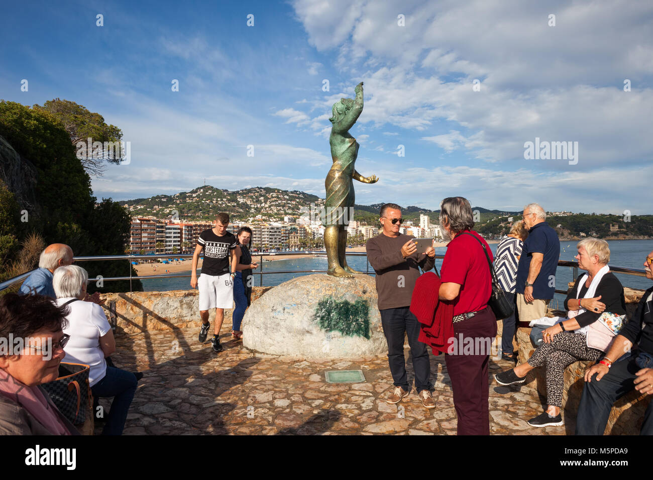 Spain, Lloret de Mar, group of people, tourists at Dona Marinera - The Fisherman's Wife monument, viewpoint on Costa Brava, Catalonia Stock Photo