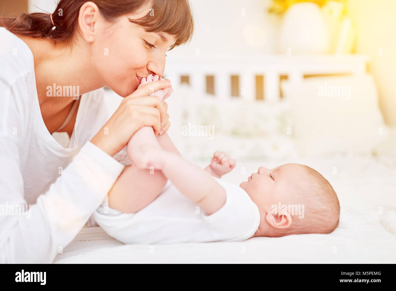 Mother plays with baby after wrapping on the changing table Stock Photo
