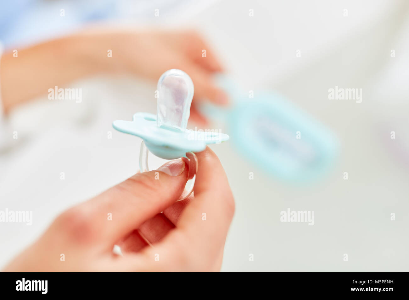 Hand holds a pacifier as a baby item for reassurance Stock Photo