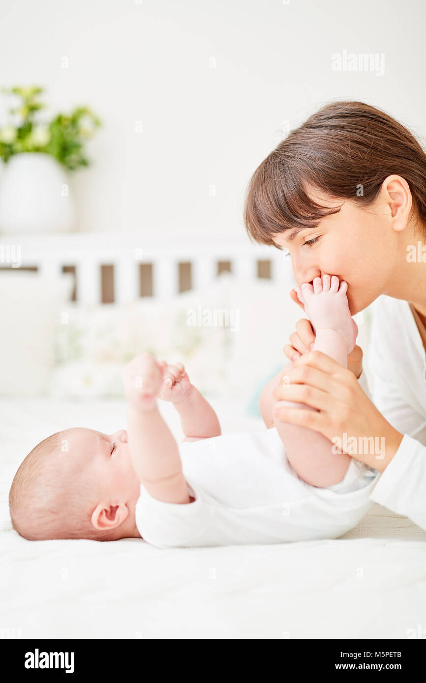 Happy mother tenderly cuddles with her newborn baby at home Stock Photo