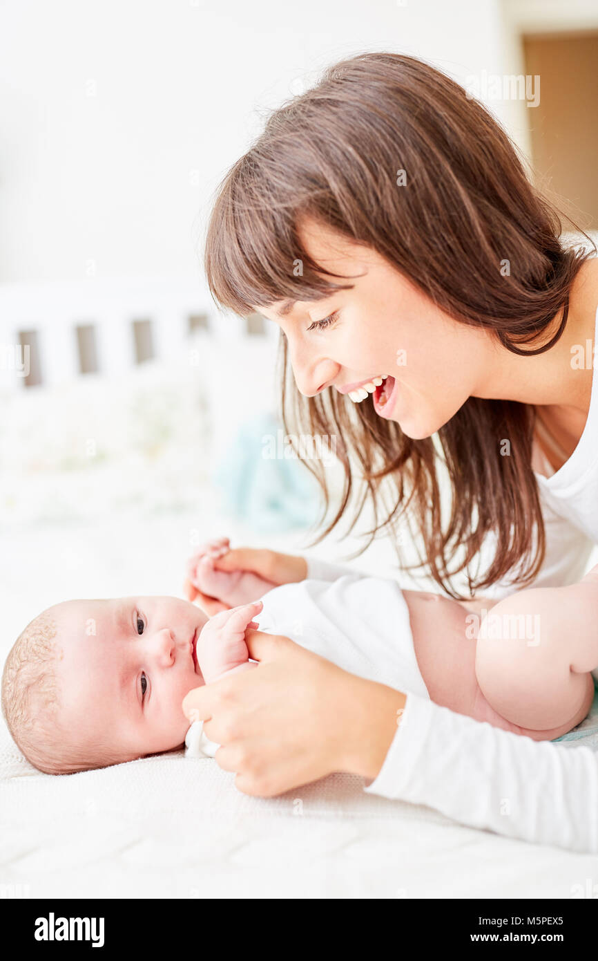 Happy mother changes the diapers with her newborn baby Stock Photo