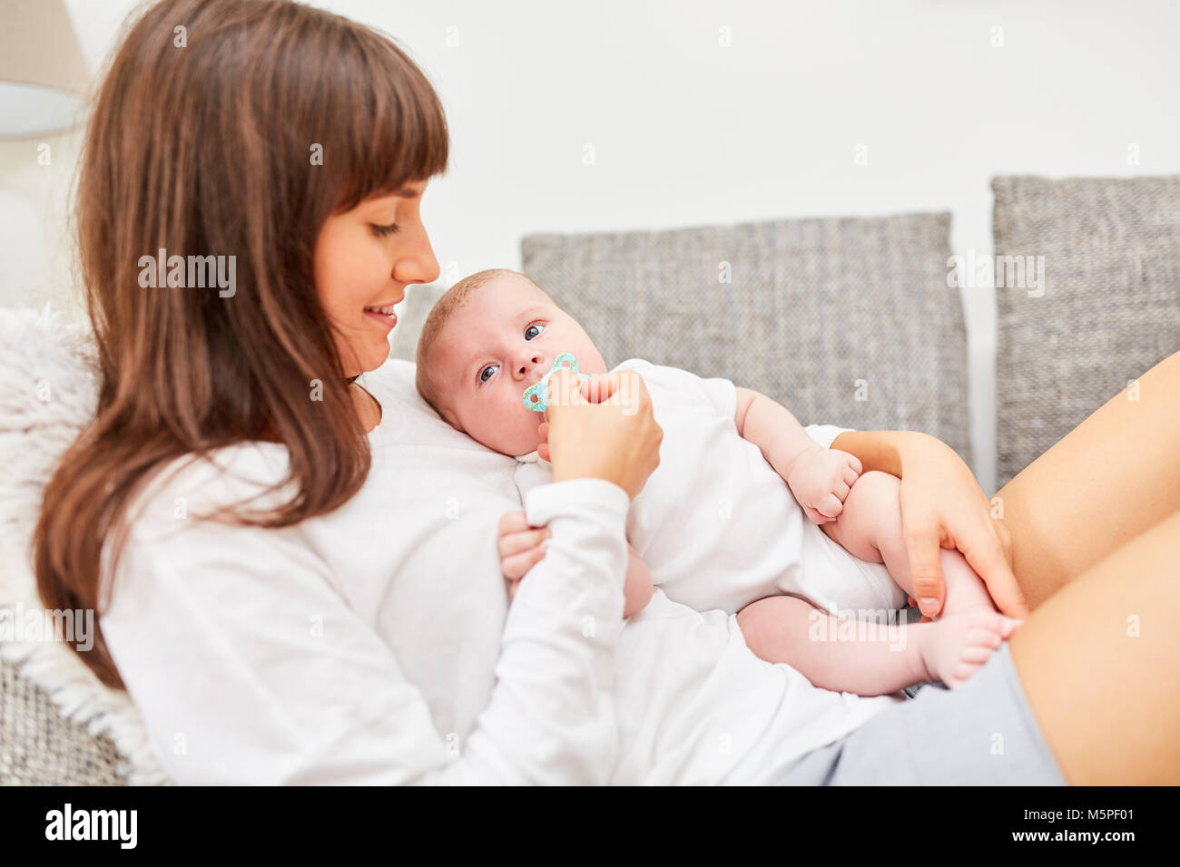 Mother caring for newborn baby with pacifier Stock Photo
