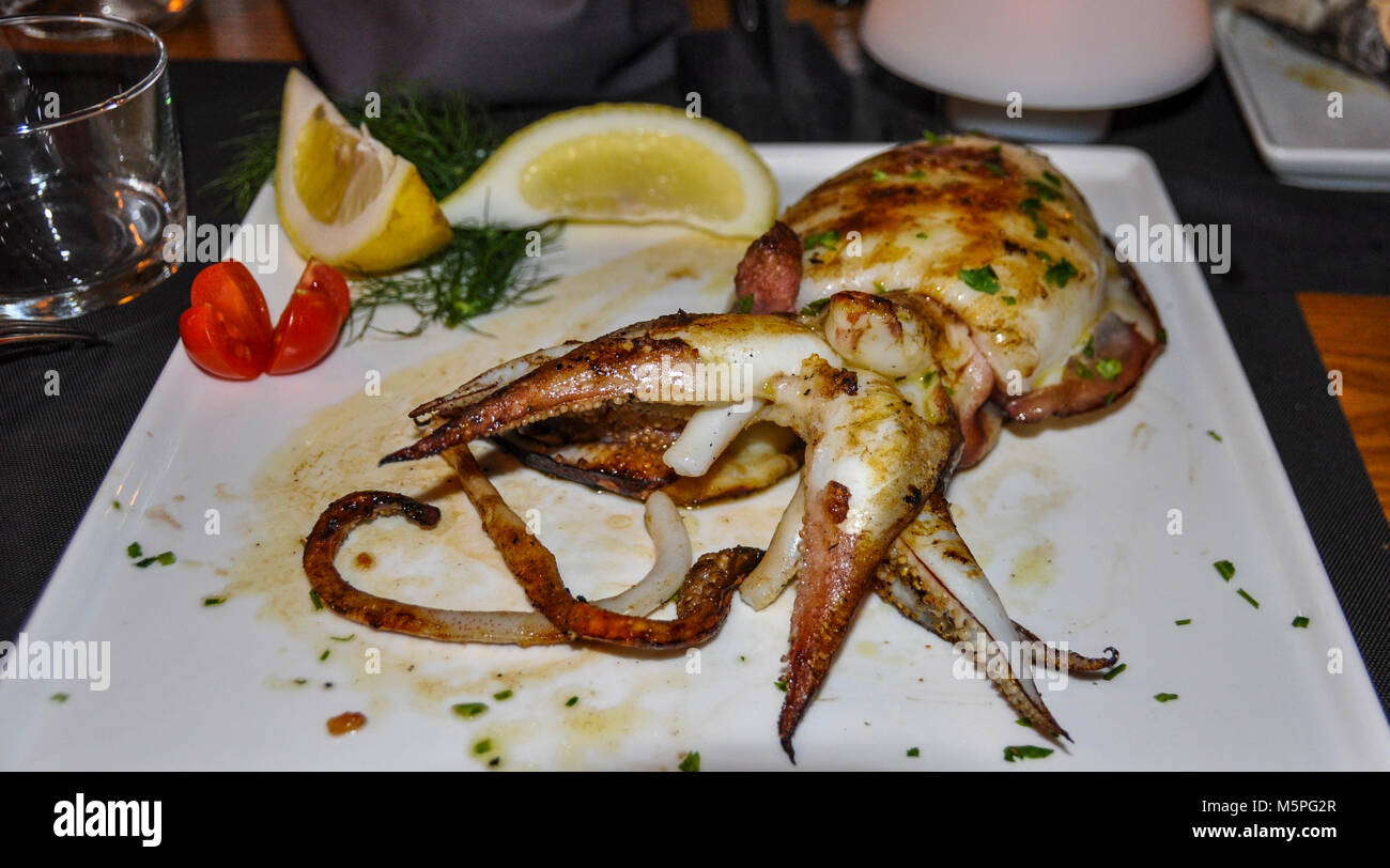 A grilled cuttlefish served for dinner at a restaurant. Stock Photo