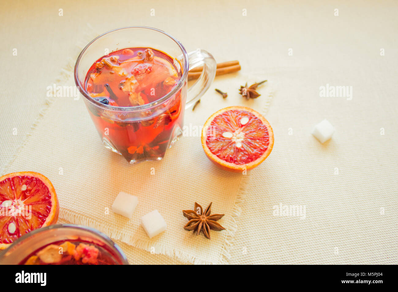 Tea made from dried fruit, seasoned with cinnamon cloves and anise seeds. There is an orange nearby Stock Photo