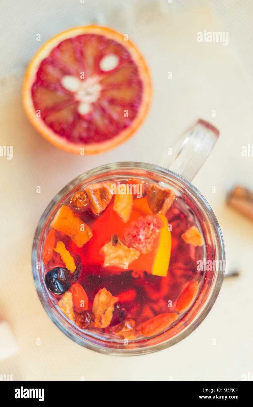 Tea made from dried fruit, seasoned with cinnamon cloves and anise seeds. There is an orange nearby Stock Photo