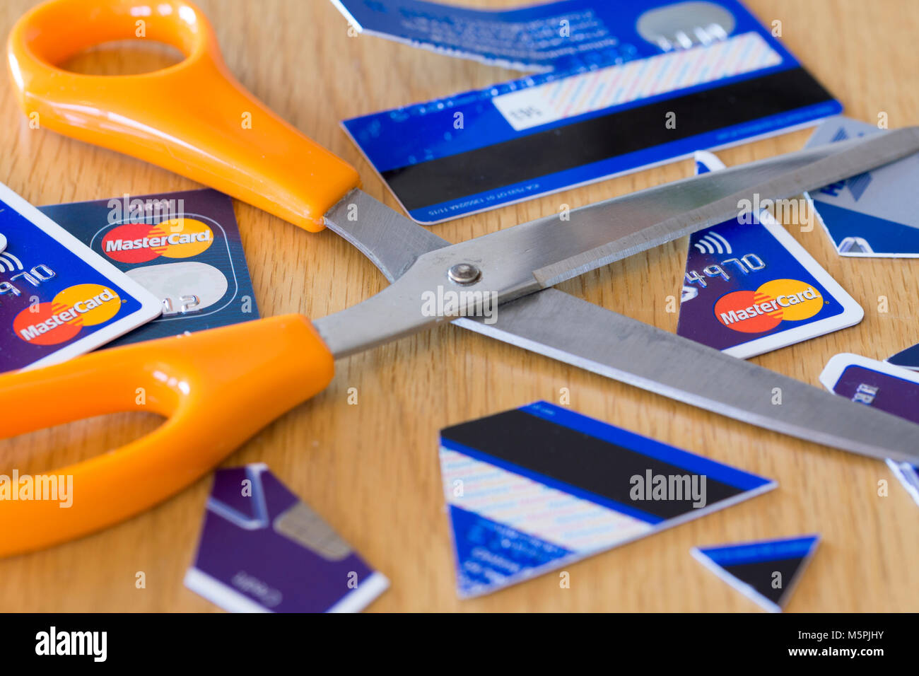 A pair of scissors in the middle of cut up credit cards - credit card debt concept Stock Photo