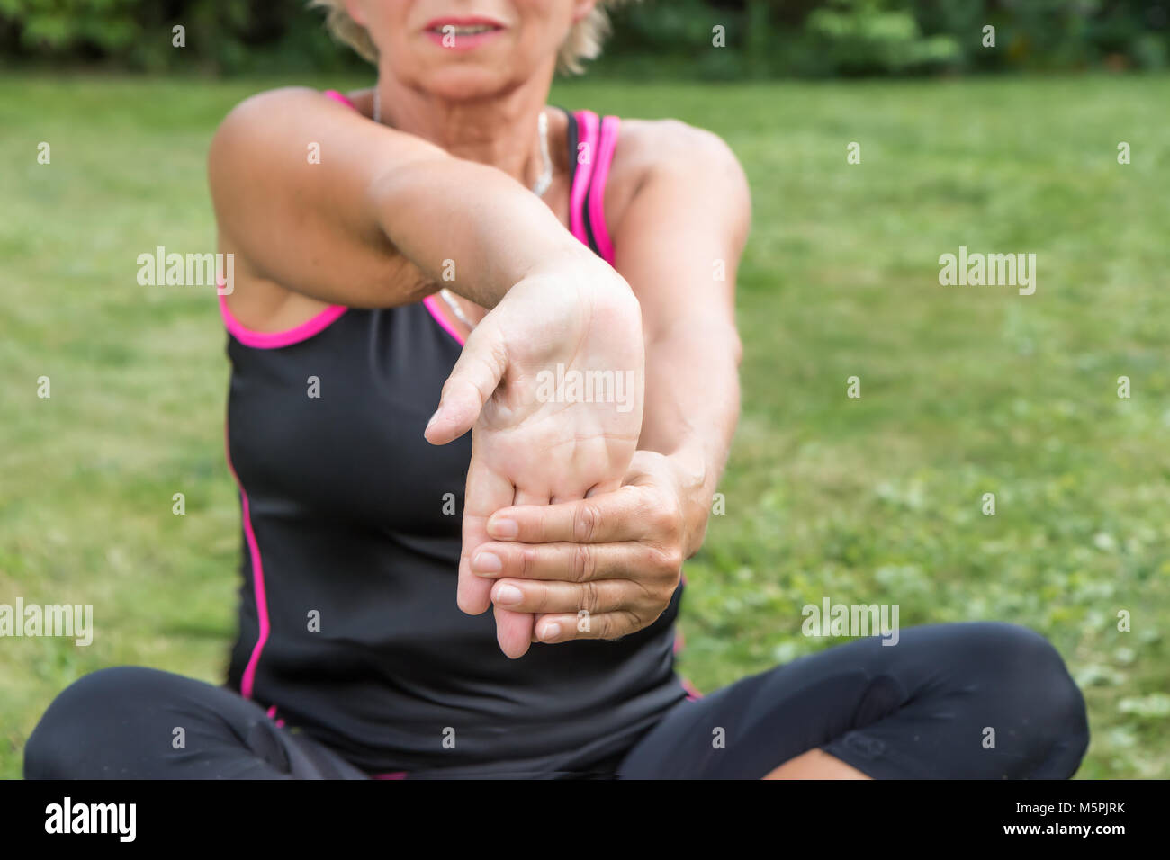 Senior woman is showing exercise for pain relief. Forearm Stretching