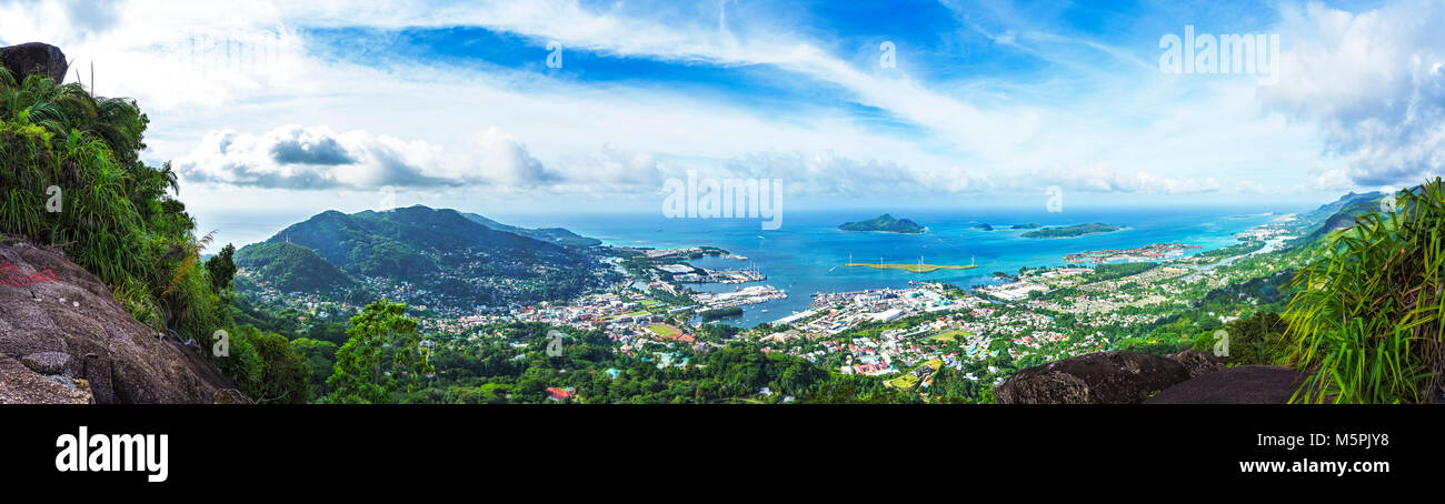 Hiking the copolia trail with granite rocks in the jungle on mahé on the seychelles. Panorama view of victoria and eden city Stock Photo