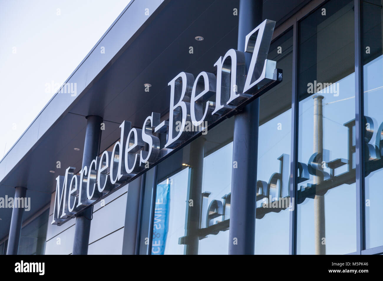 FUERTH / GERMANY - FEBRUARY 25, 2018: Mercedes-Benz logo hangs on a car dealer building. Mercedes-Benz is a global automobile marque and a division of Stock Photo