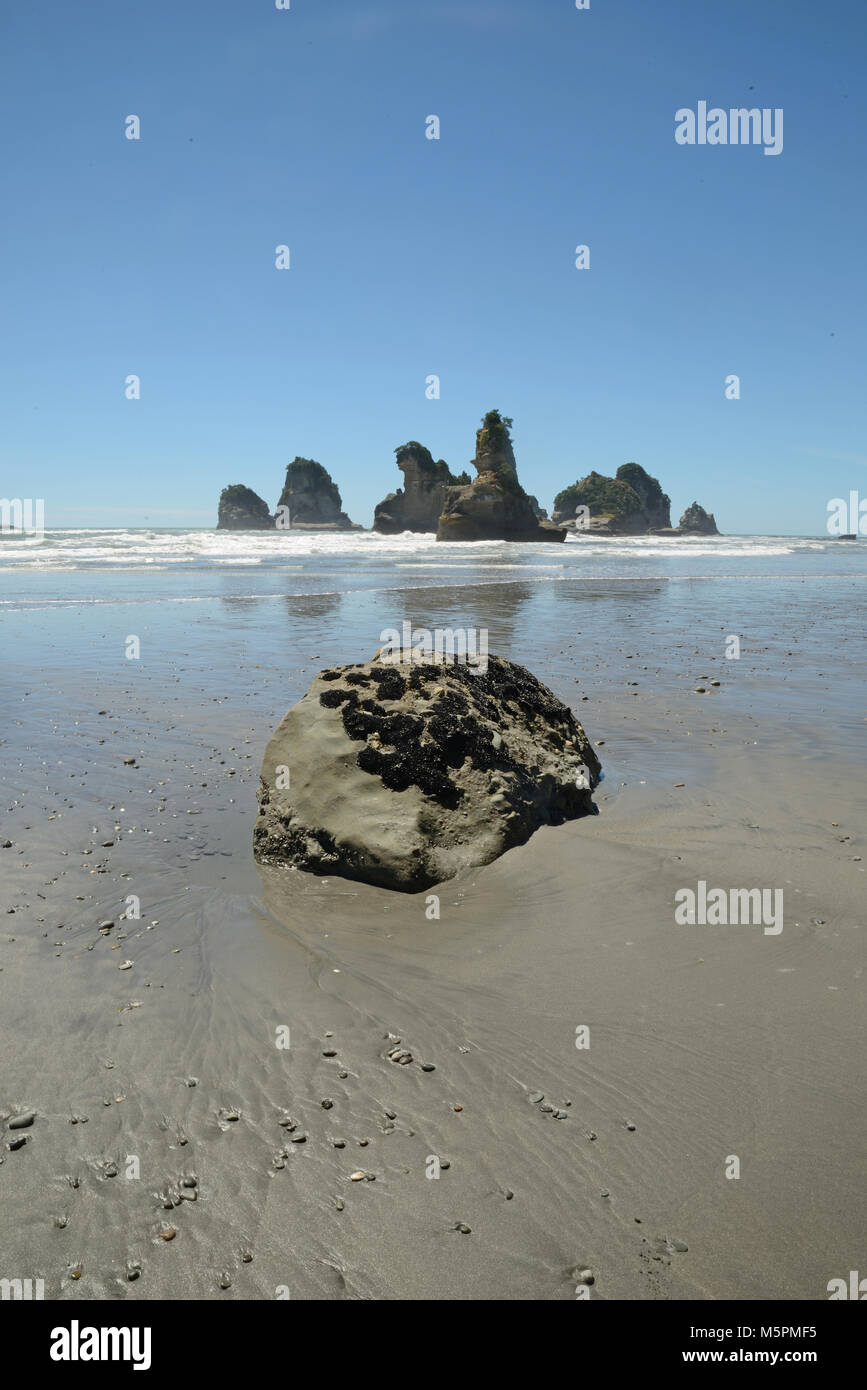 low tide reveals a group of small islands at a West Coast beach, South Island, New Zealand Stock Photo
